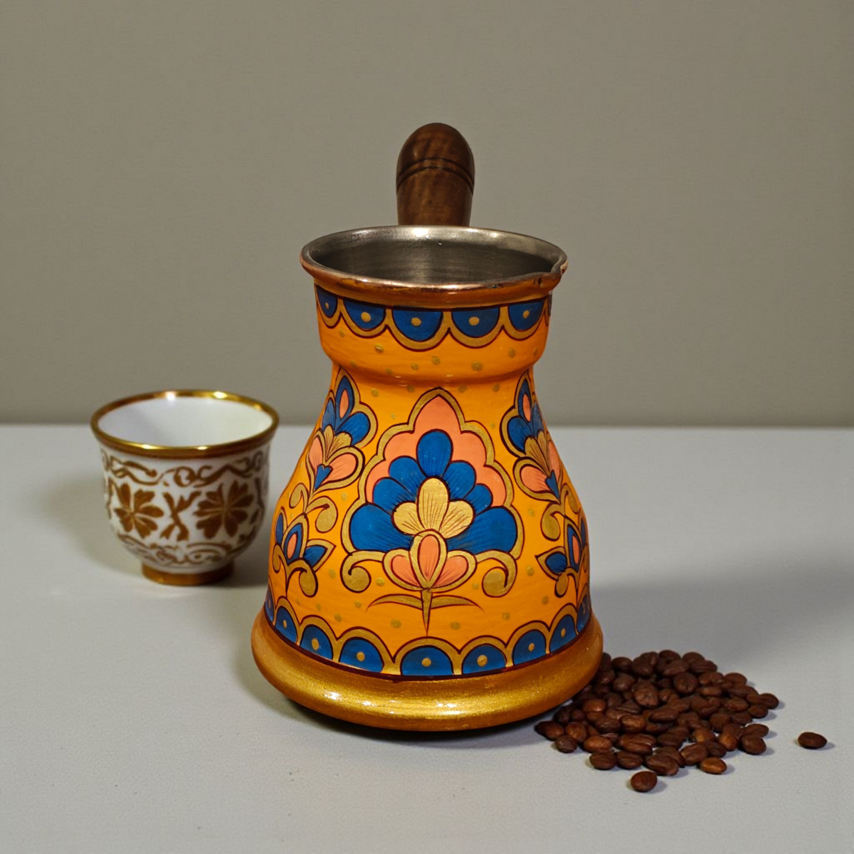 front view of the traditional hand-painted copper Turkish coffee pot with wooden handle orange cezve 400ml floral motifs design by Dastkaari